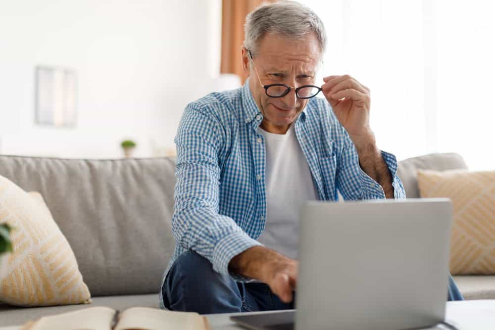 a male senior having a hard time reading